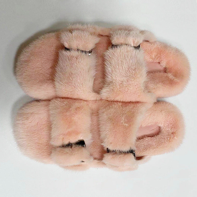 Pair of pink fur slippers on a light gray background