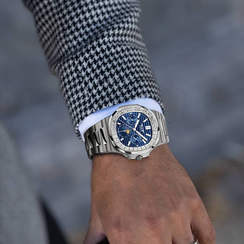 Silver watch with a blue face on a person's wrist, blurred background