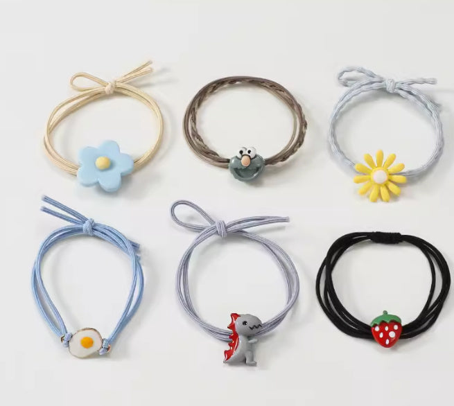 Set of colorful hair ties with decorative ends on a white background