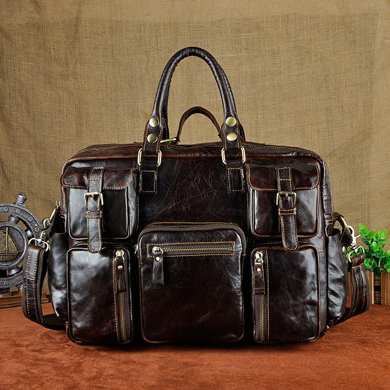 Brown leather briefcase with multiple pockets and zippers on a textured brown background