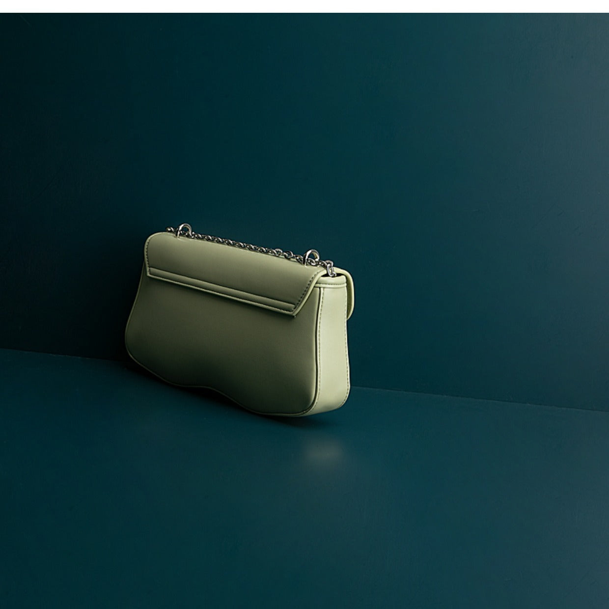Green handbag on a dark green background