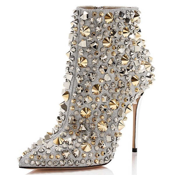 High-heeled shoe with gold and silver embellishments on a white background