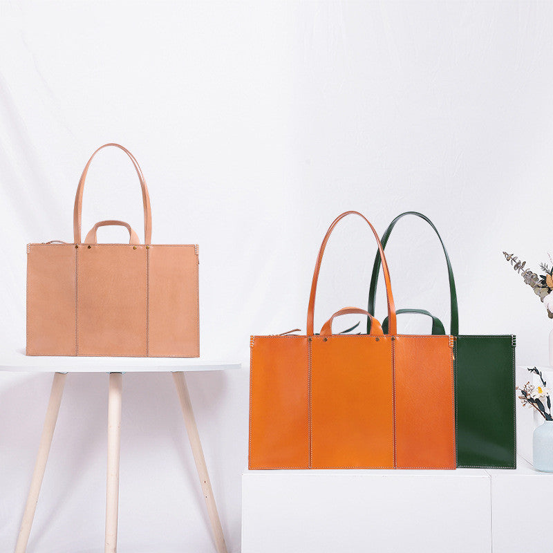 Three leather handbags in brown, orange, and green on a white background