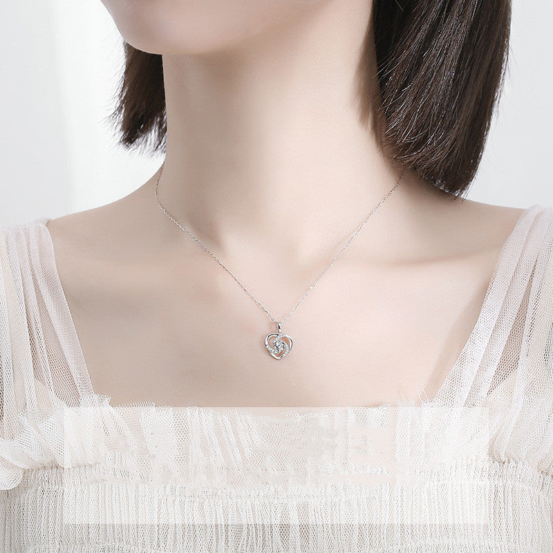 Necklace with a floral pendant on a mannequin wearing a white dress.