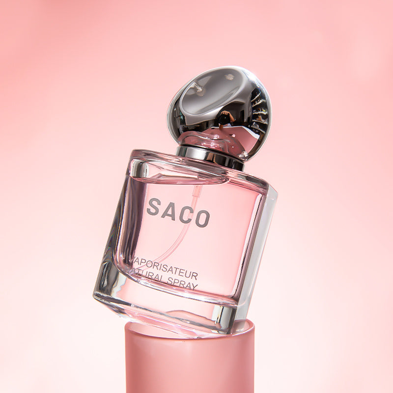 Perfume bottle labeled 'SACO' on a pink background