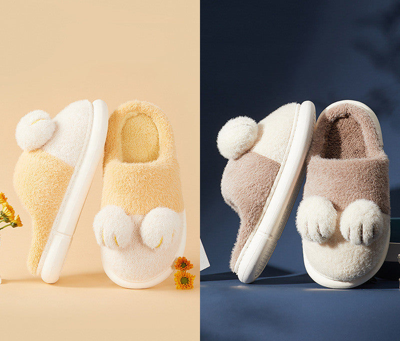 Pair of fluffy slippers with pom-poms on a beige and blue background