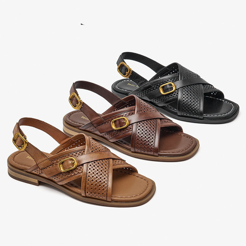 Brown and black sandals with gold buckles on a white background