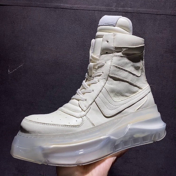 White high-top sneaker with transparent sole held against a dark background