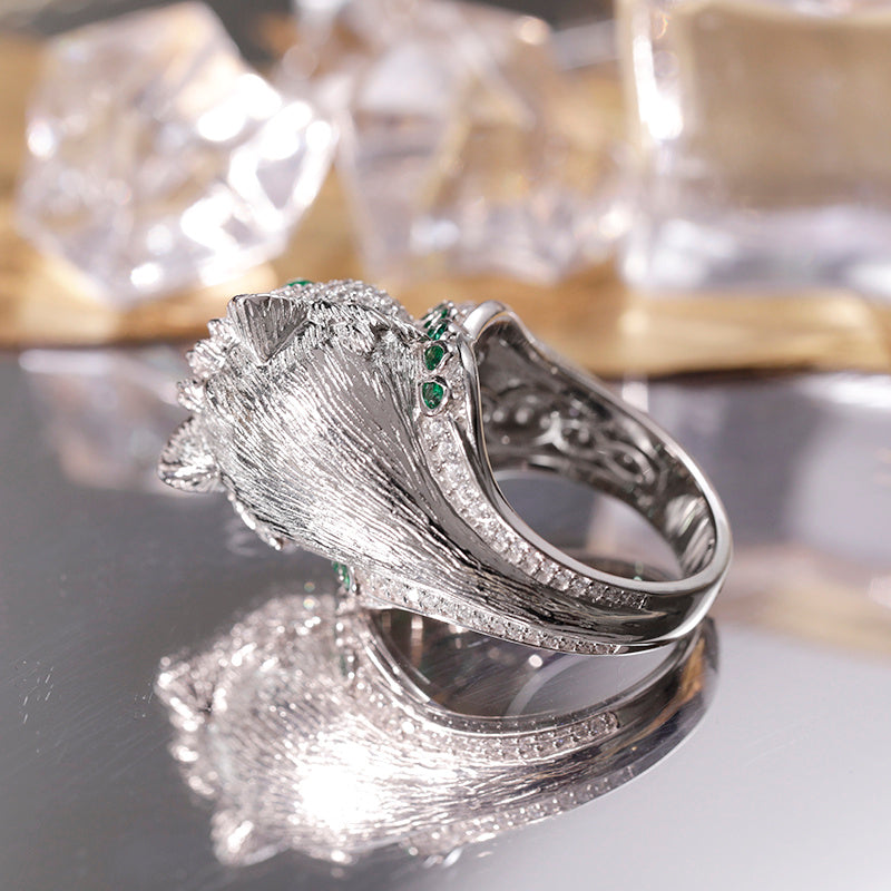 Silver ring with gemstones on a reflective surface