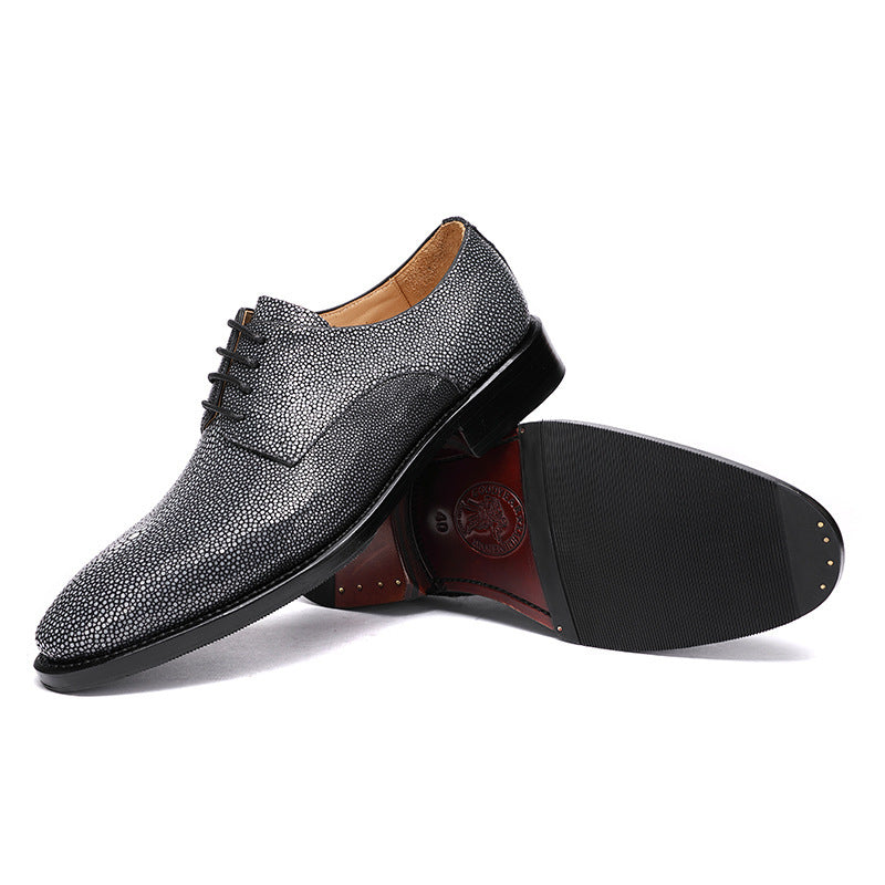 Gray textured dress shoe with a black sole on a white background