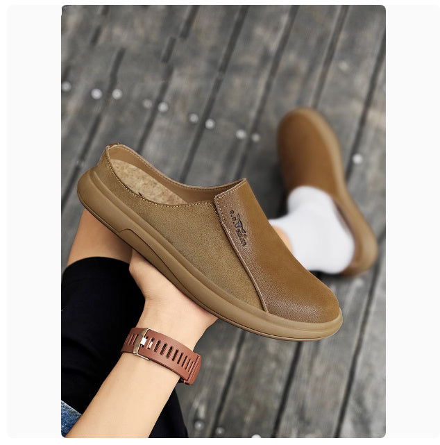 Brown slip-on shoes being worn on a wooden floor