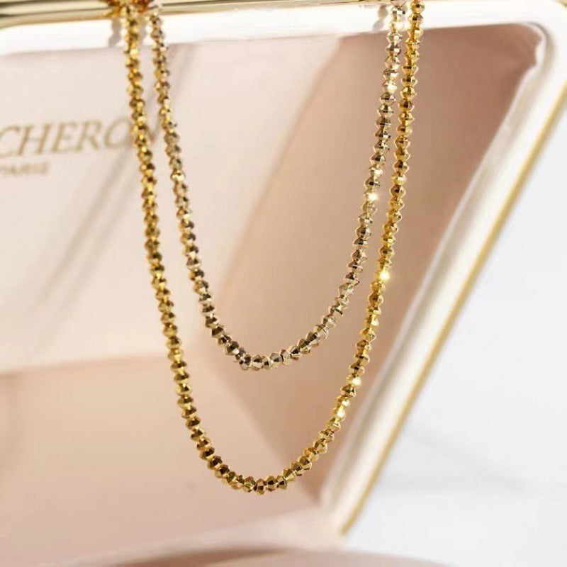 Gold necklace on a light pink stand with 'Cherq' branding.