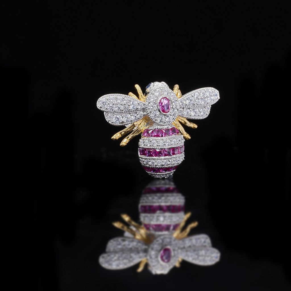 Jeweled bee brooch with pink gemstone on a black background