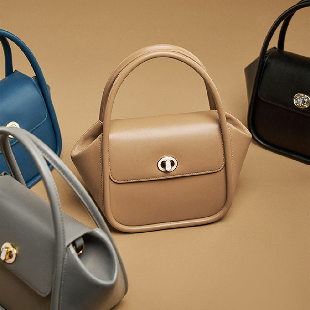 Beige handbag with a gold clasp on a beige background