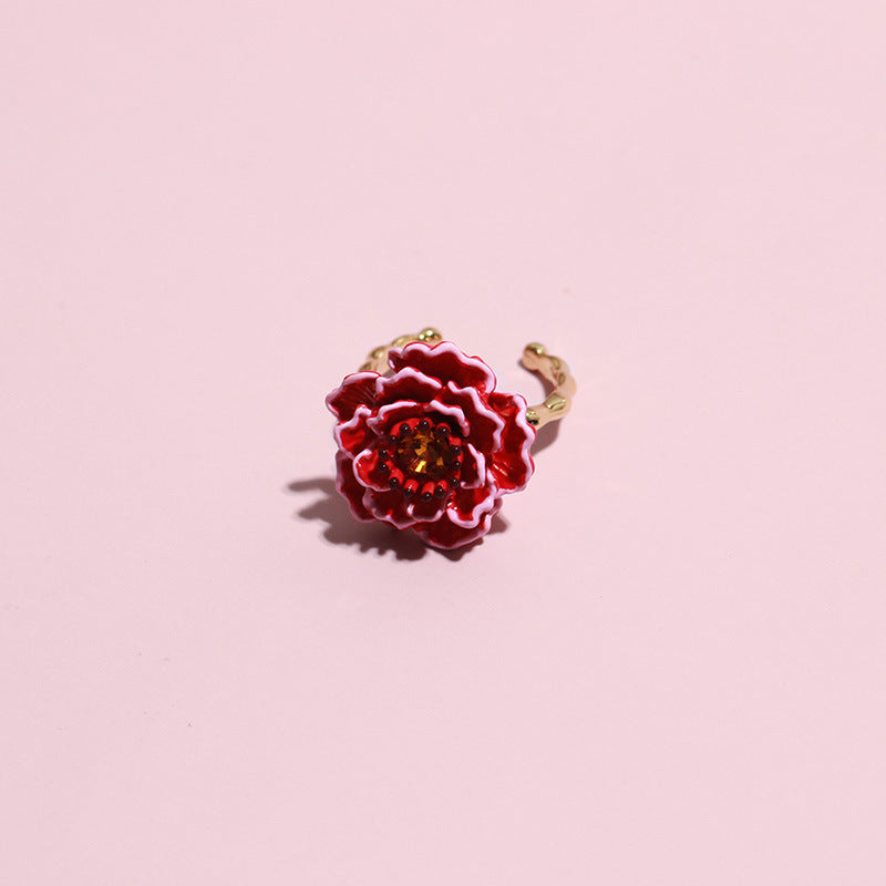 Red flower-shaped ring on a pink background