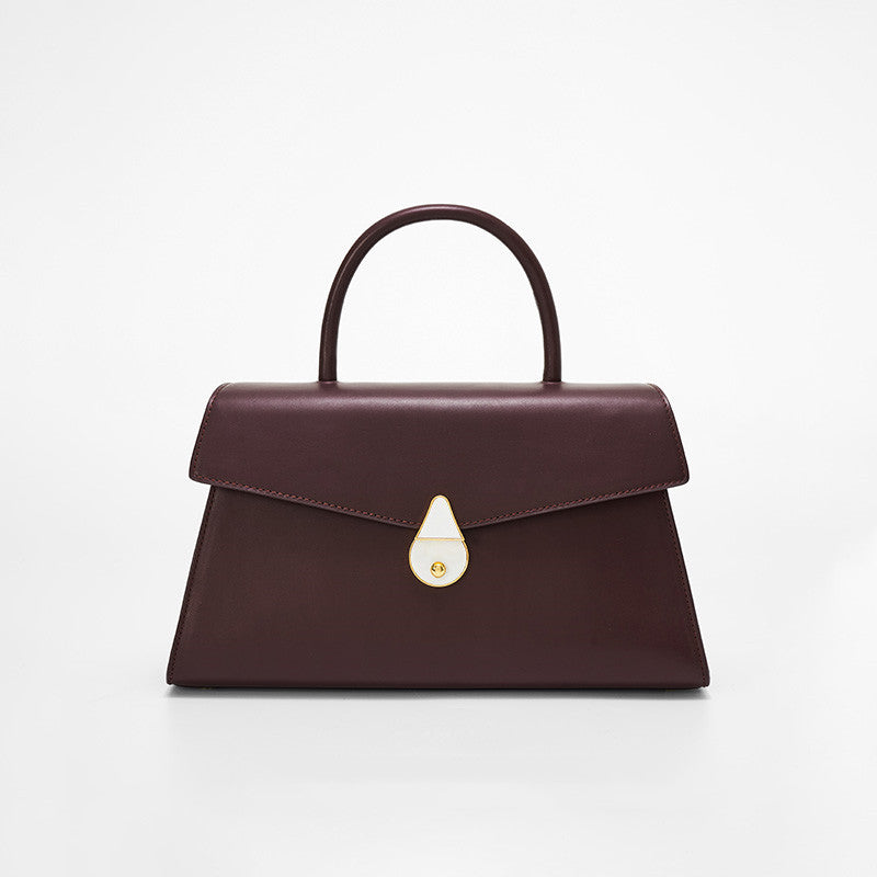 Brown handbag with a gold clasp on a white background