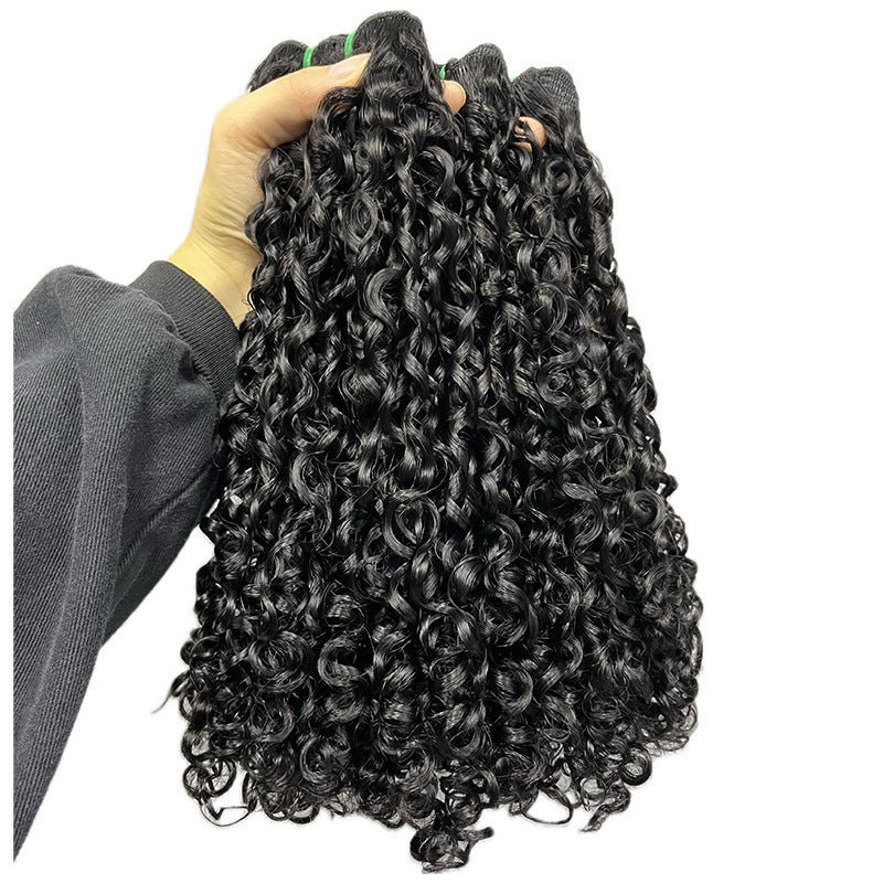 Black curly hair extensions held by a person with a white background