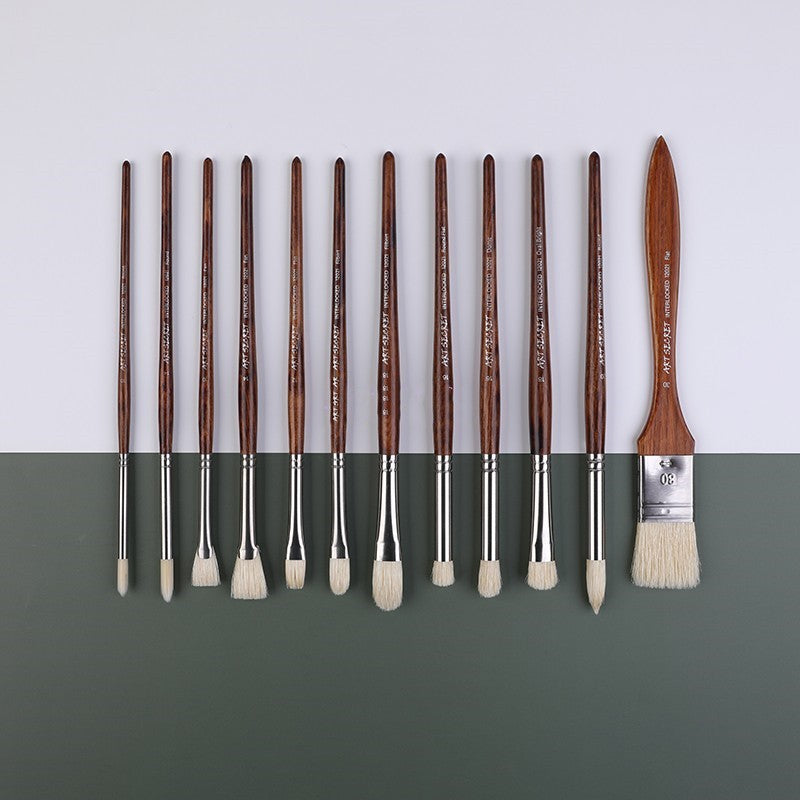 Set of paint brushes with brown handles and silver ferrules on a gray background