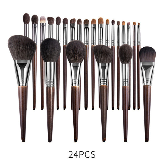 Set of 24 makeup brushes with brown handles and black bristles on a white background.