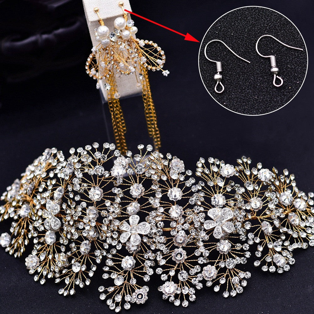 Large decorative headpiece with intricate details on a dark background, showing close-up of earring hooks.