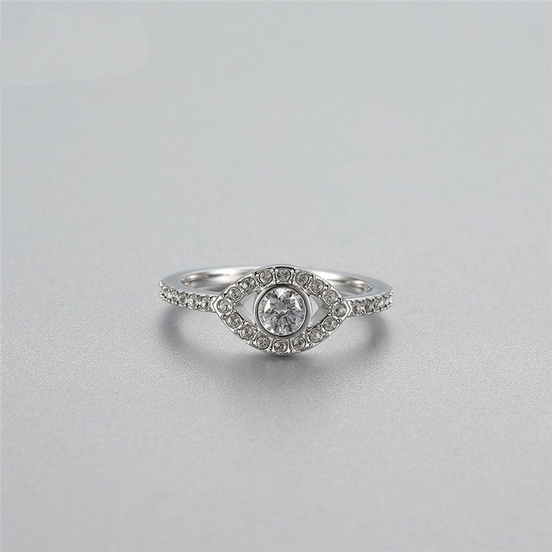 Silver ring with a central diamond on a light gray background