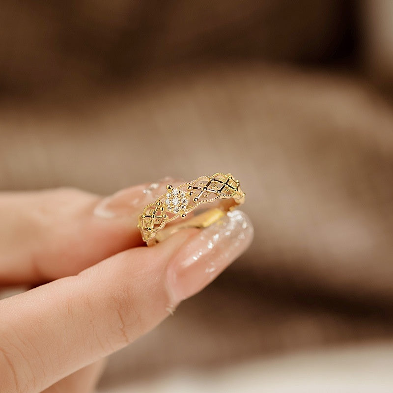 Gold ring with intricate design on a blurred background