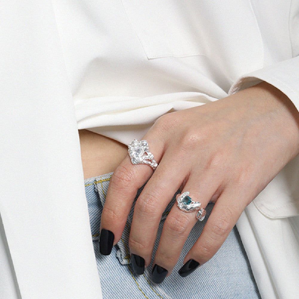 Close-up of a hand wearing two diamond rings on a white background