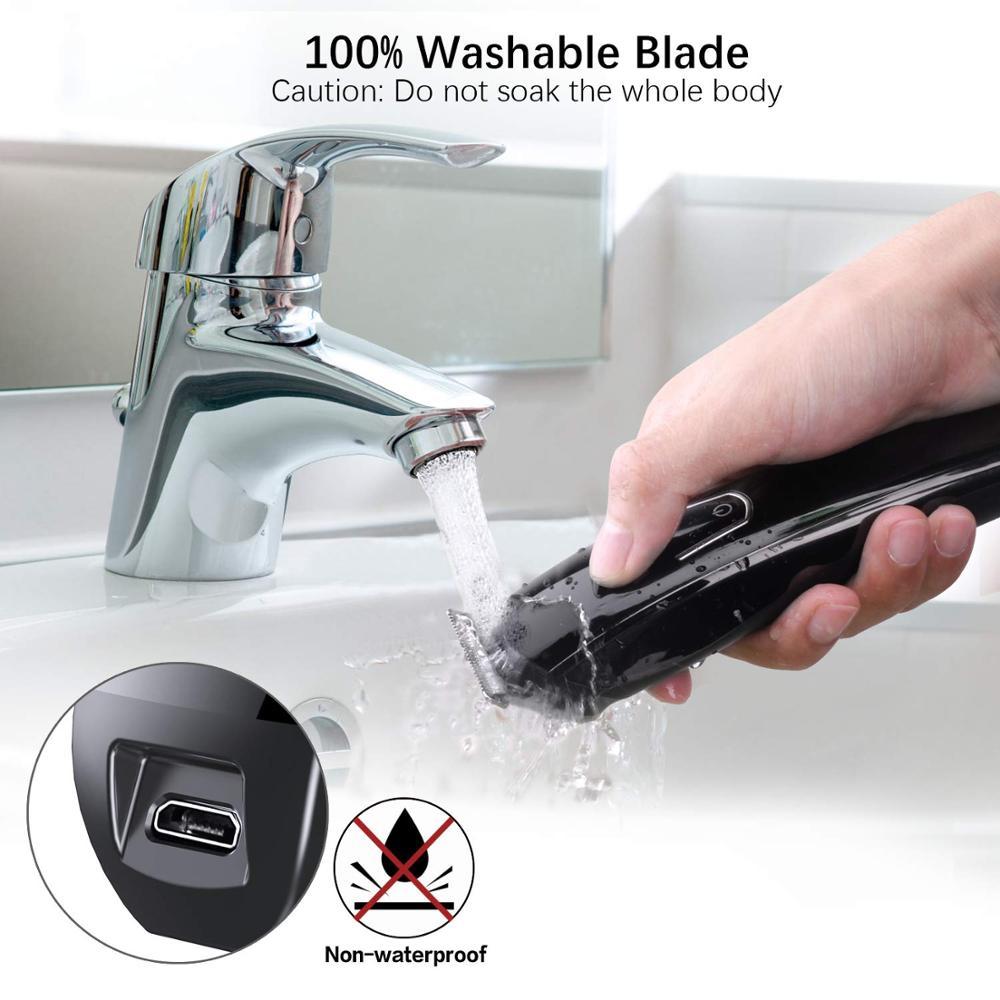 Hand washing a black electric razor under running water with safety warning icons displayed.
