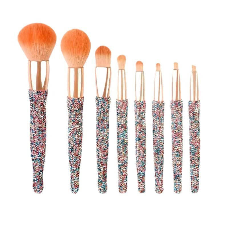 Set of makeup brushes with colorful handles on a white background