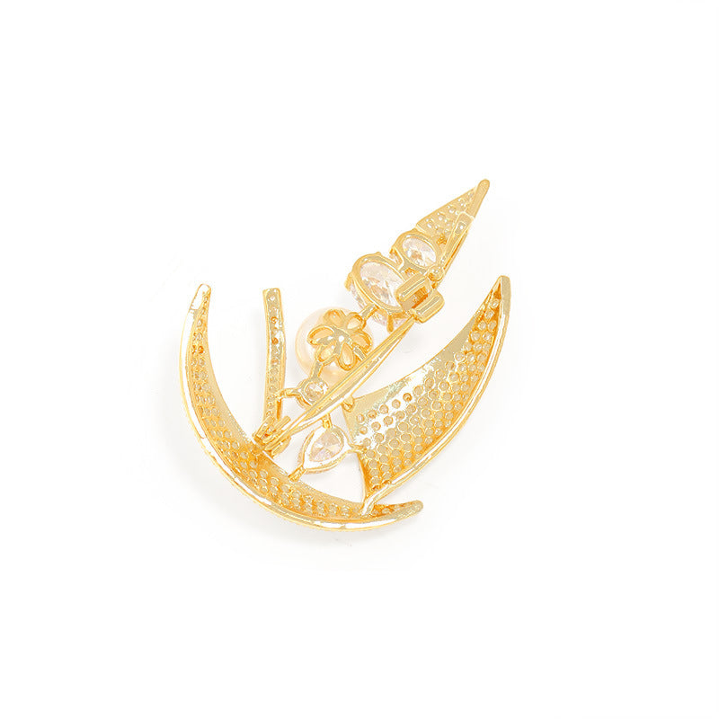 Gold brooch with intricate design on a white background