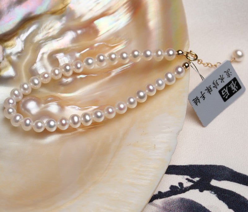 Pearl necklace with a tag on a shell background