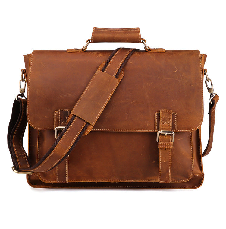 Brown leather satchel bag with shoulder strap on a white background