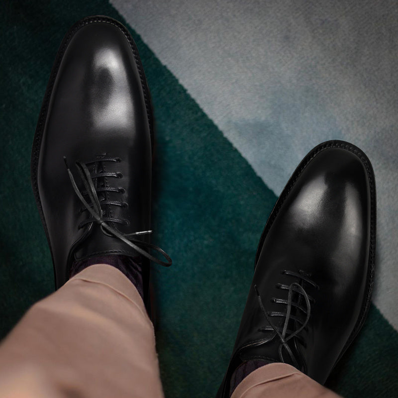 Black dress shoes on a patterned carpet