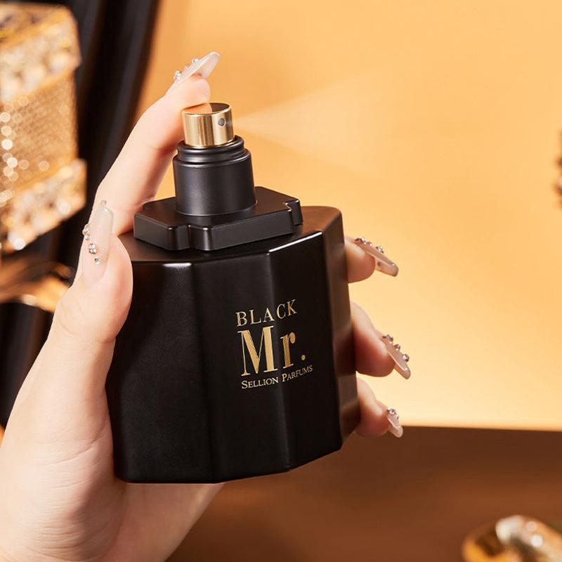Black 'Mr. Sullion Parfums' perfume bottle held by a hand with a blurred background