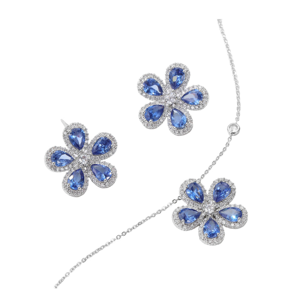 Flower-shaped jewelry set with blue stones on a white background