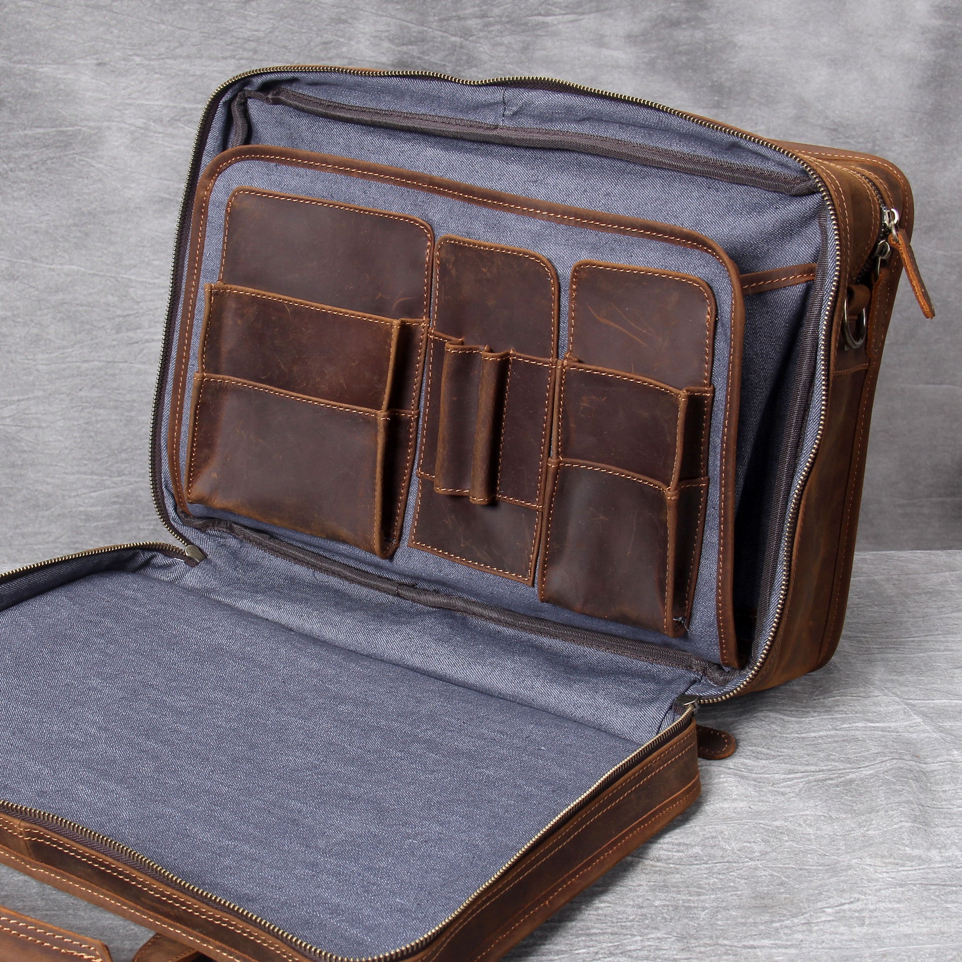 Open leather briefcase with gray interior on a gray background