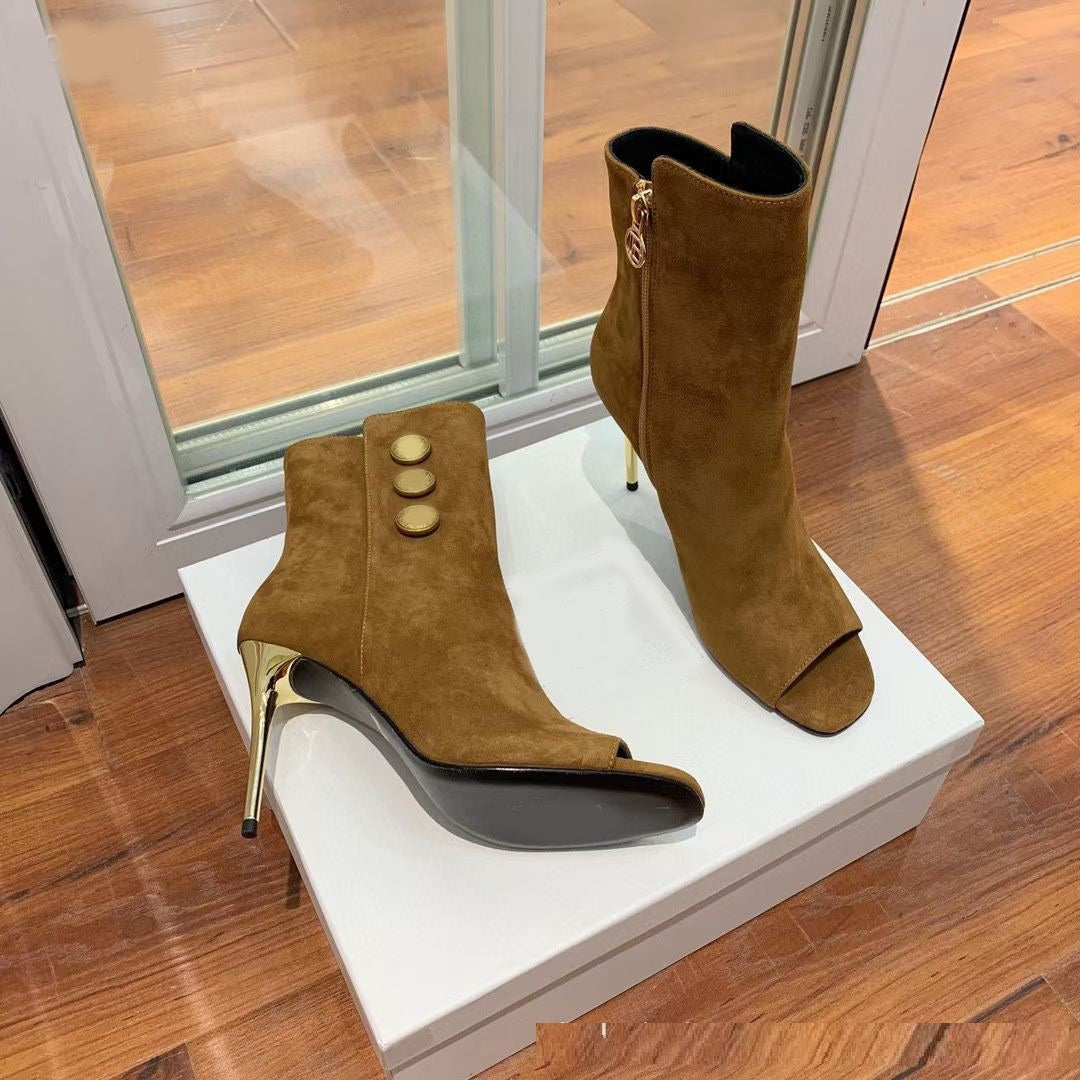 Brown suede high-heeled boots with gold buttons on a white platform.