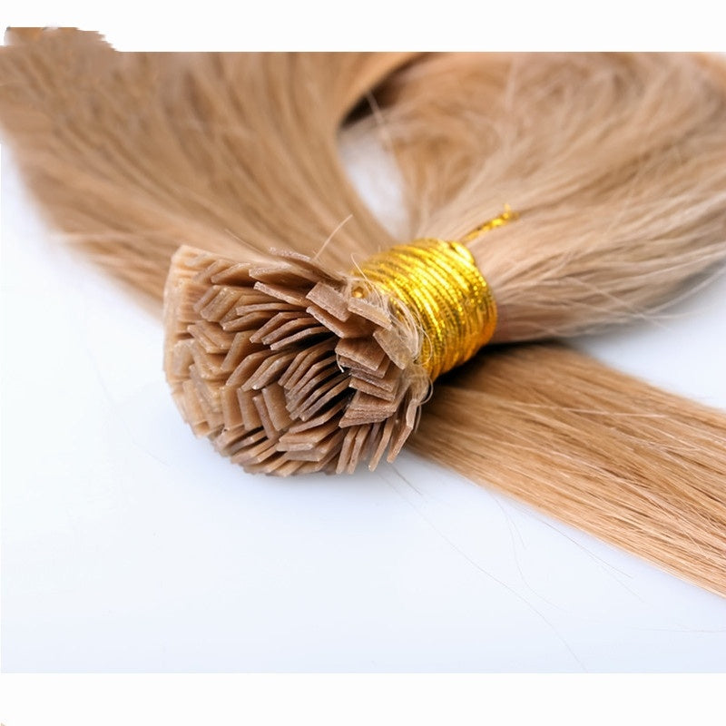 Blonde hair extensions with a gold tie on a white background