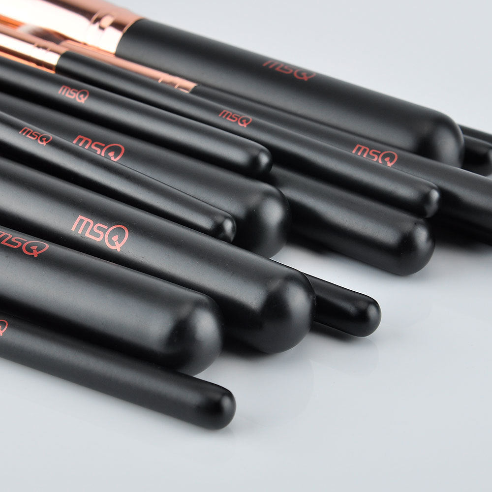 Set of black makeup brushes with rose gold accents and 'MSQ' branding on a light gray background.