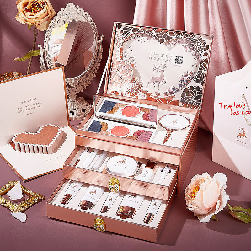 Makeup set with various items in a decorative box on a pink background