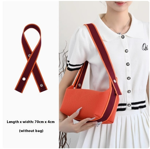 Orange crossbody bag with red strap held by a person, with strap dimensions displayed.