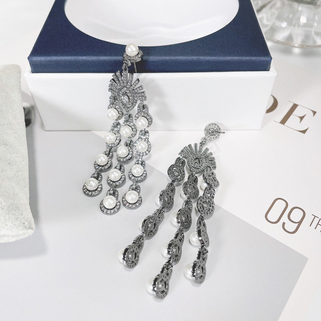 Pair of silver earrings with pearls on a white surface
