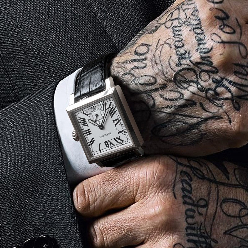 Watch on a tattooed wrist with a dark background