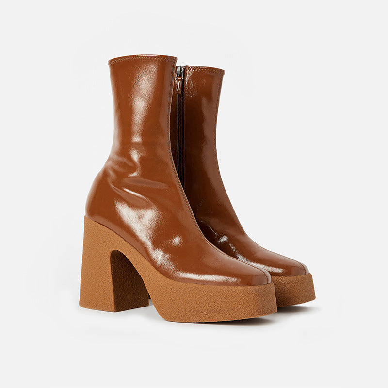 Pair of brown leather ankle boots with chunky heels on a white background