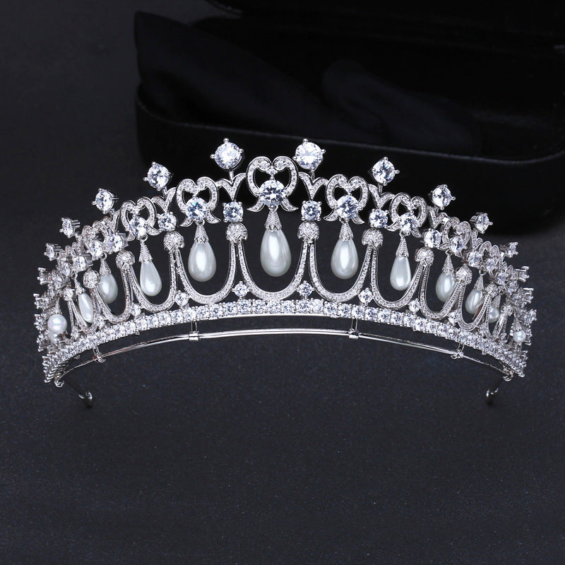 Elegant tiara with pearls and crystals on a black background