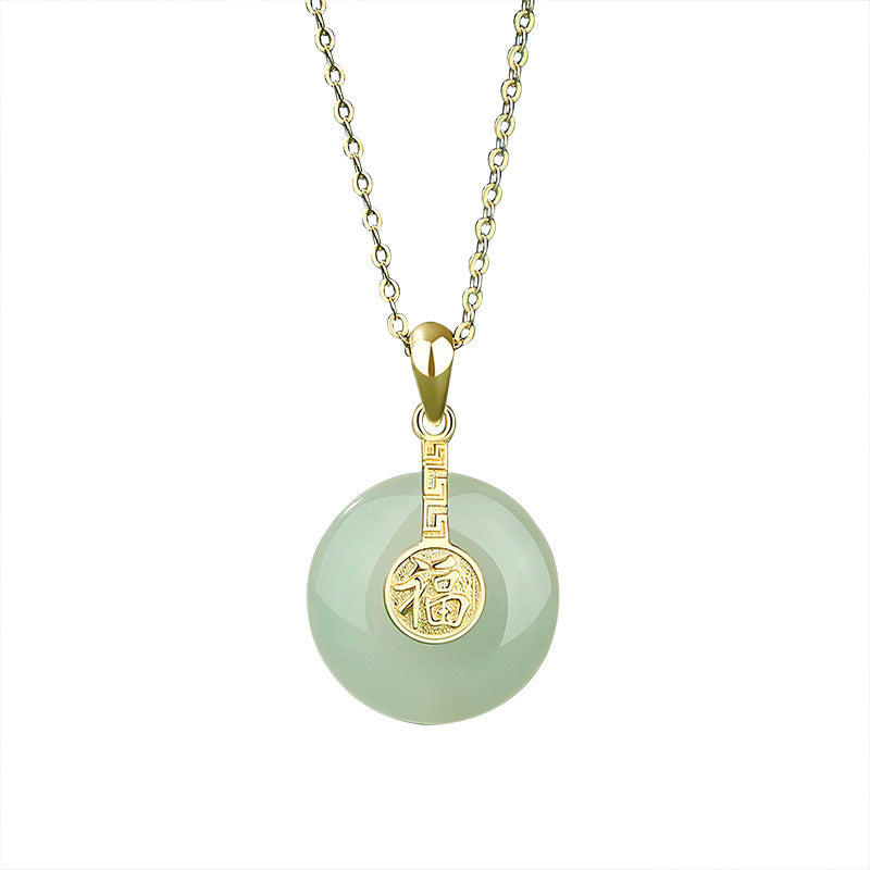 Necklace with a green jade pendant and gold chain on a white background