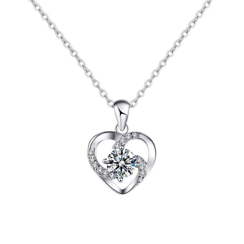 Silver heart-shaped pendant necklace with a clear gemstone on a white background
