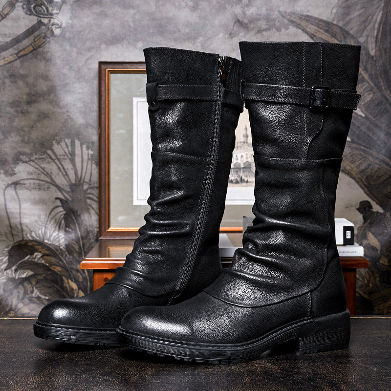 Pair of black leather knee-high boots on a textured surface with a decorative background.