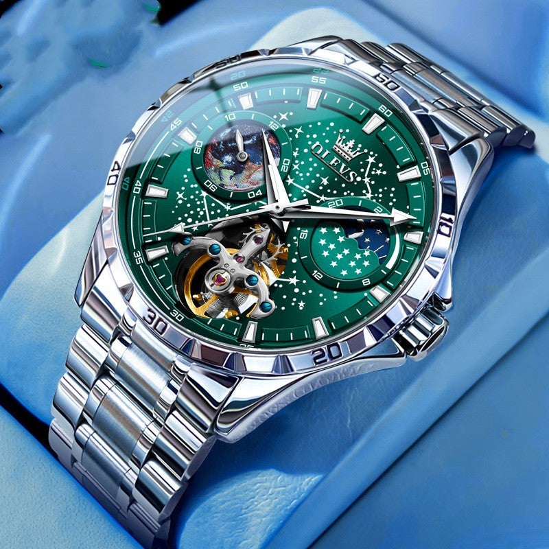 Luxury watch with green face and silver metal strap on a blue background