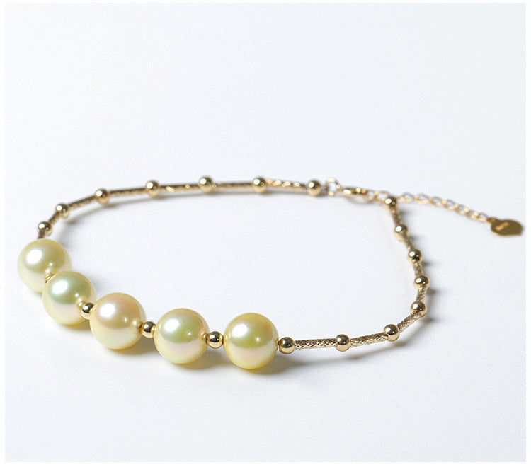 Pearl bracelet with gold accents on a white background